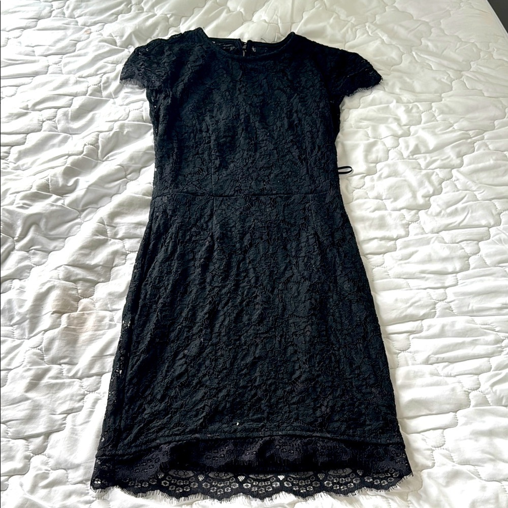 Elegant Black Lace Dress the brand is called about us and it has an open back.